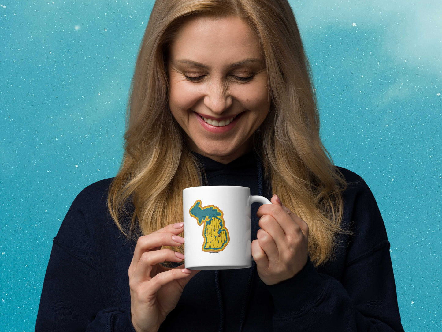 frankenmuth coffee mug, 11oz, held in hand, female, handle on right, blue sky background