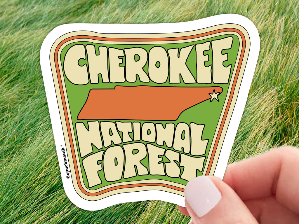 cherokee national forest sticker, held in hand, grass background