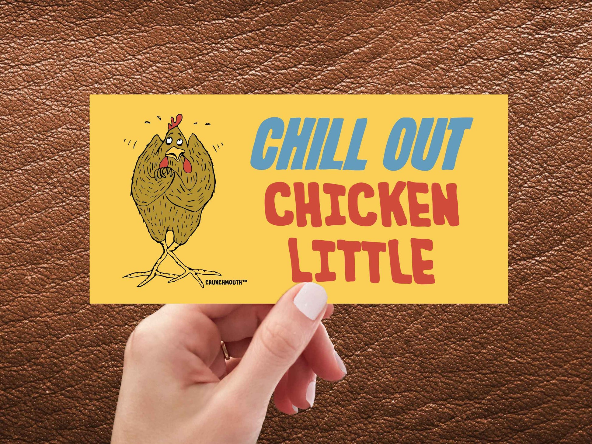 chill out chicken little bumper sticker, hand display, brown leather textured background