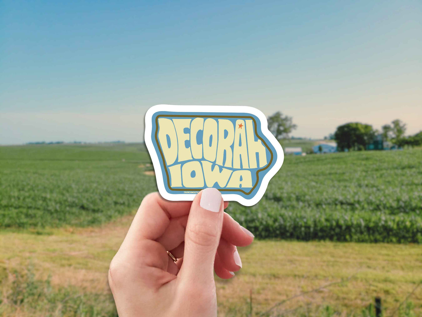 decorah iowa travel luggage sticker, hand display, farm landscape background