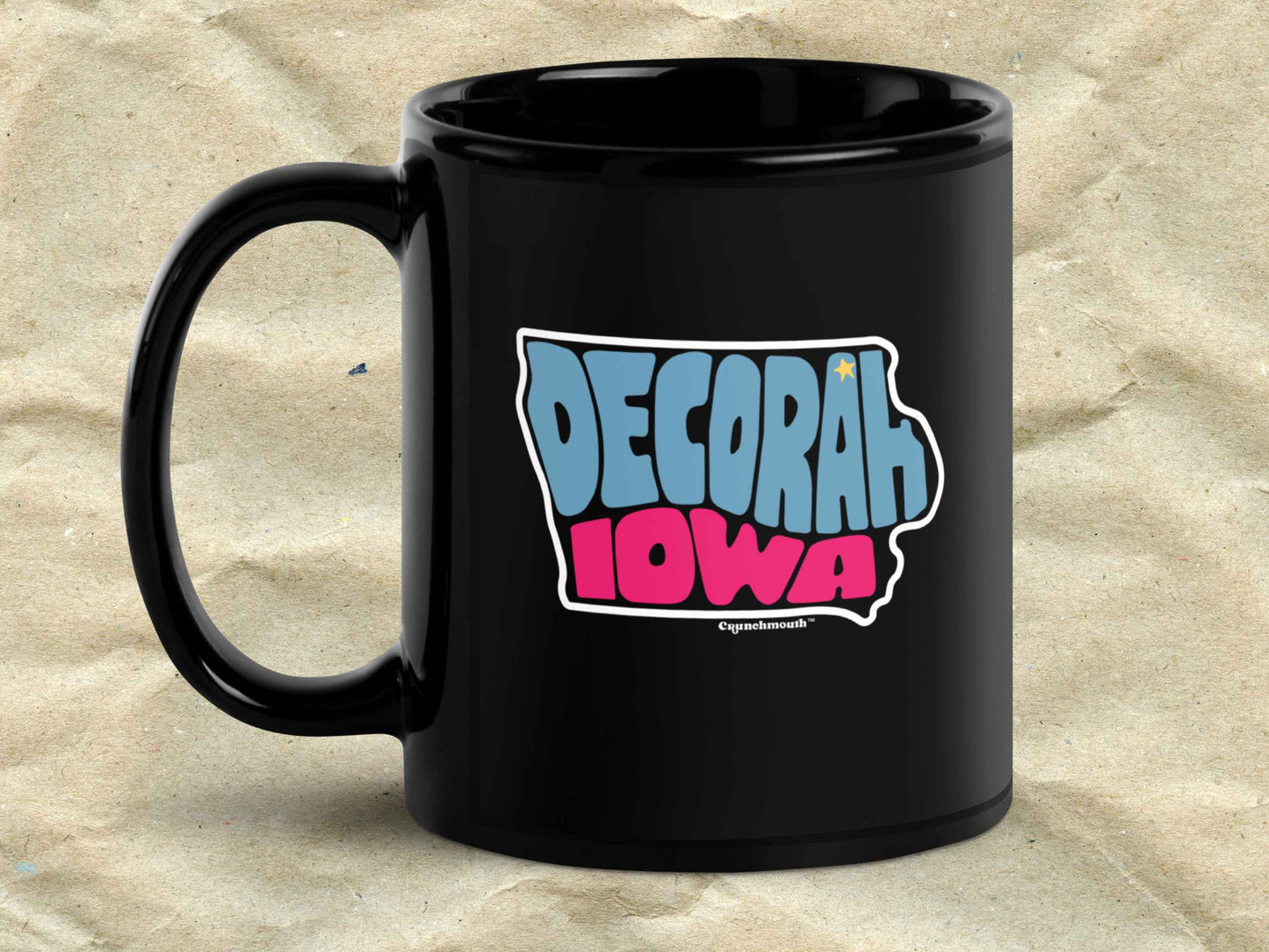 decorah mug, souvenir coffee mugs, 11oz, black ceramic, handle on left, brown textured background