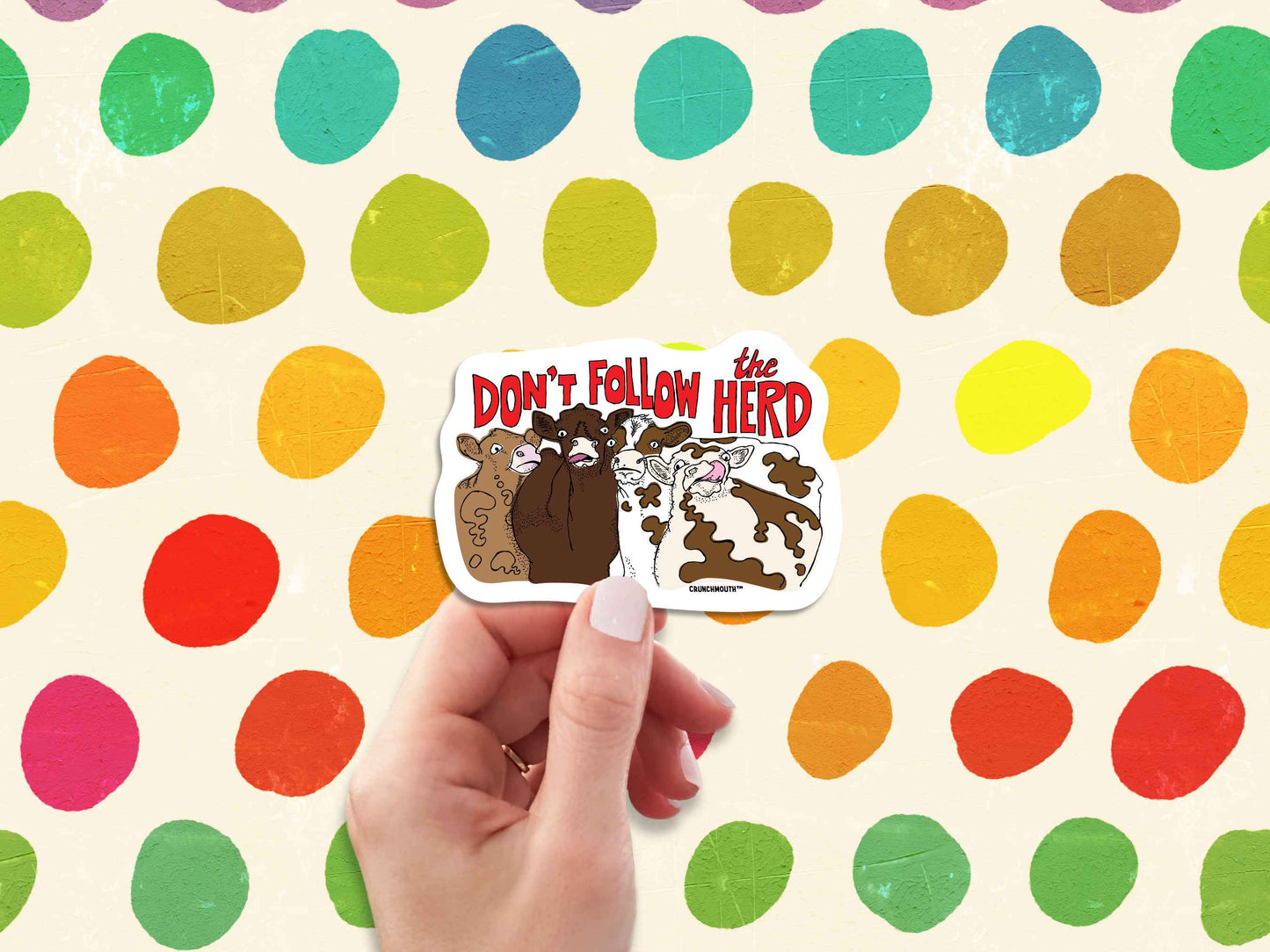 don't follow the herd sticker, hand display, colorful polka dot background