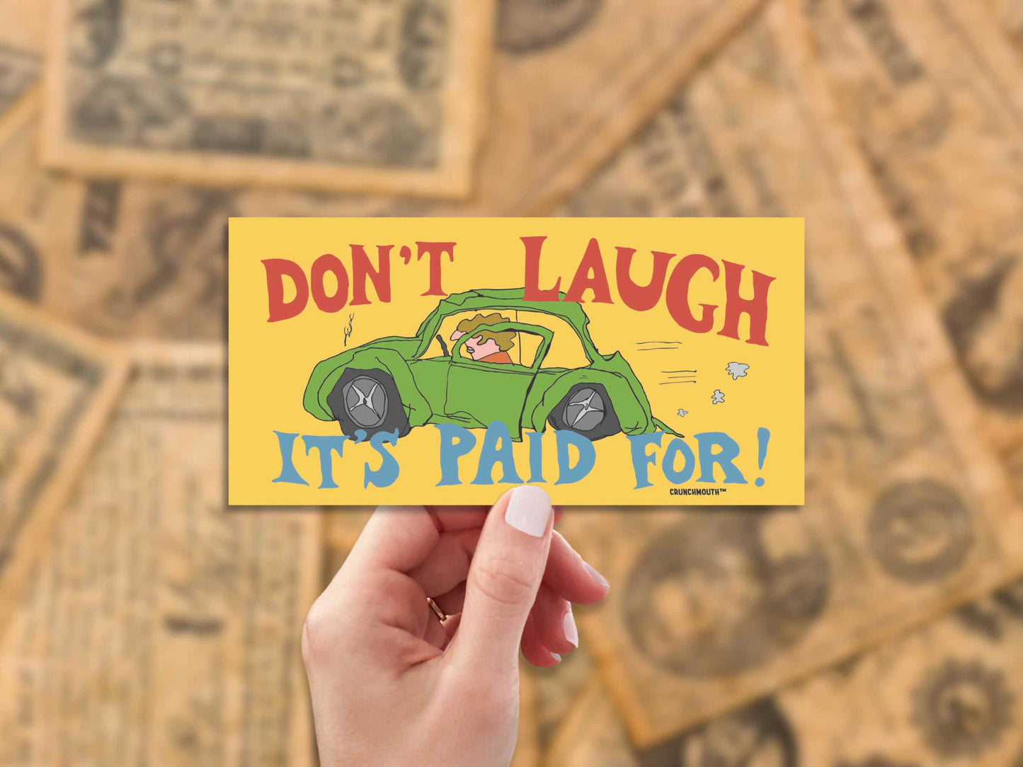 don't laugh it's paid for, funny bumper stickers, hand display, blurred antique currency background