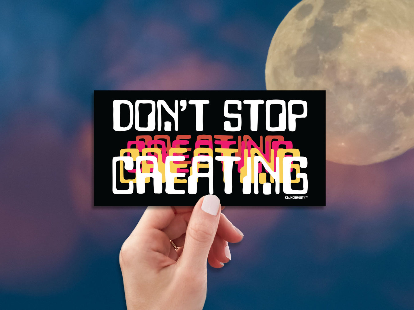 don't stop creating bumper sticker, hand display, sky moon night background