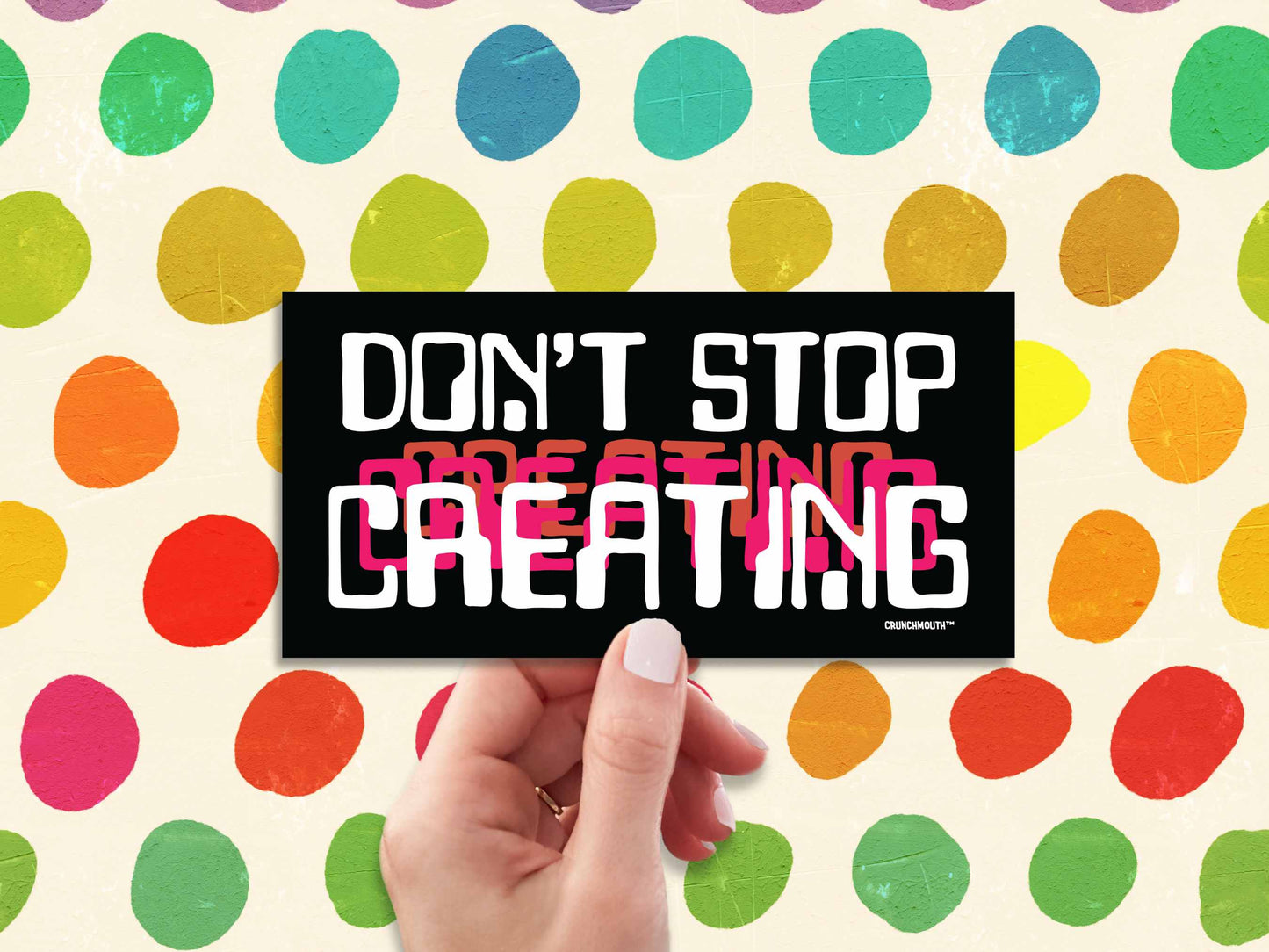 don't stop creating bumper sticker, hand display, colorful polka dot background