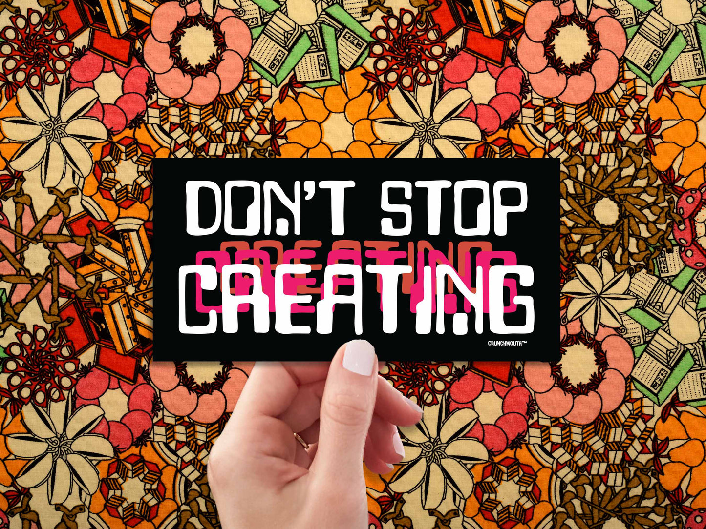 don't stop creating bumper sticker, hand display, 1970s floral pattern fabric background