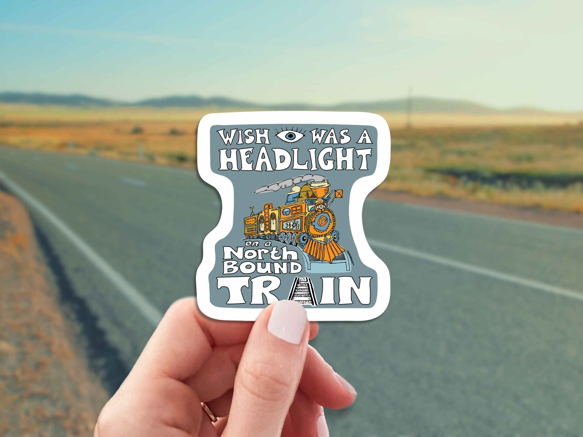 wish i was a headlight on a northbound train sticker, hand display, country highway background