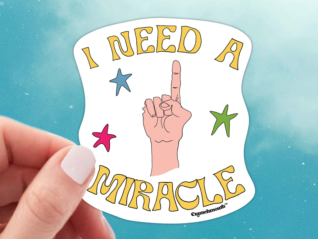 i need a miracle waterproof vinyl laptop sticker, held in hand, blue sky background