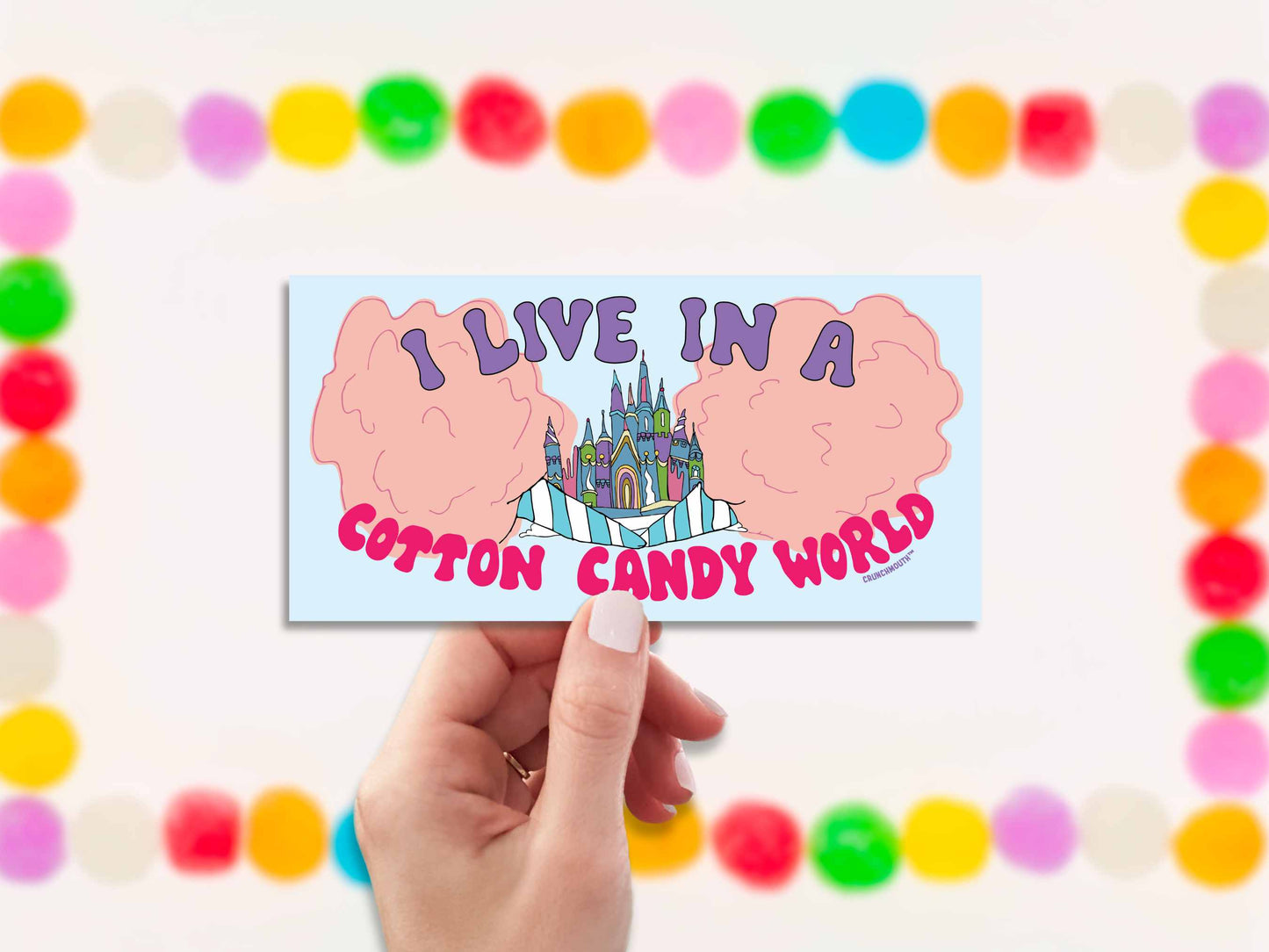 i live in a cotton candy world bumper sticker, hand display, gumdrops background