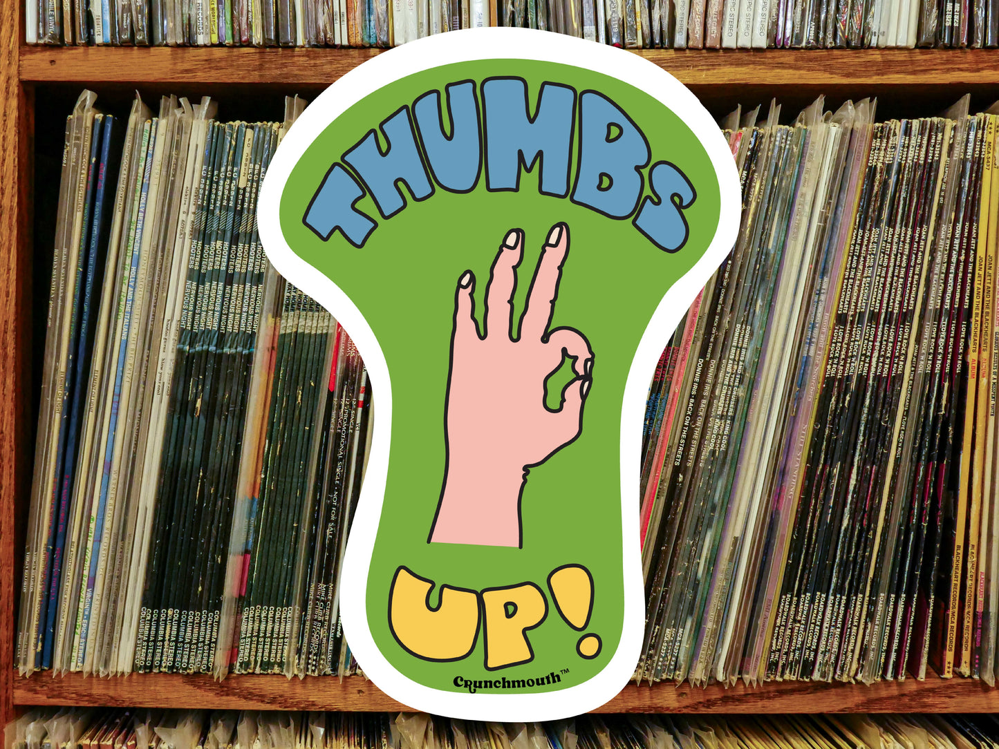 thumbs up sticker, vinyl record shelf background