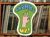 thumbs up sticker, vinyl record shelf background