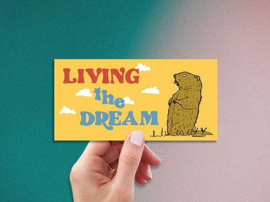 living the dream, funny groundhog bumper sticker, hand display, grainy gradient background