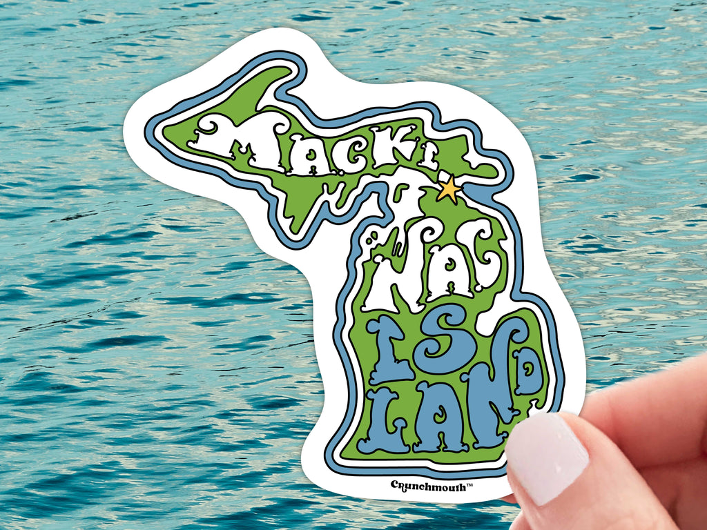 mackinac island waterproof vinyl sticker, held in hand, water background
