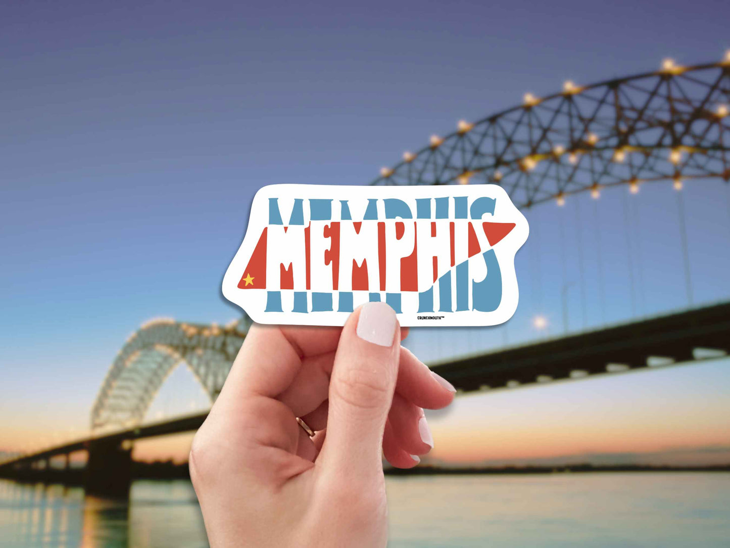 memphis travel luggage sticker, hand display, hernando desoto bridge over the mississippi river background