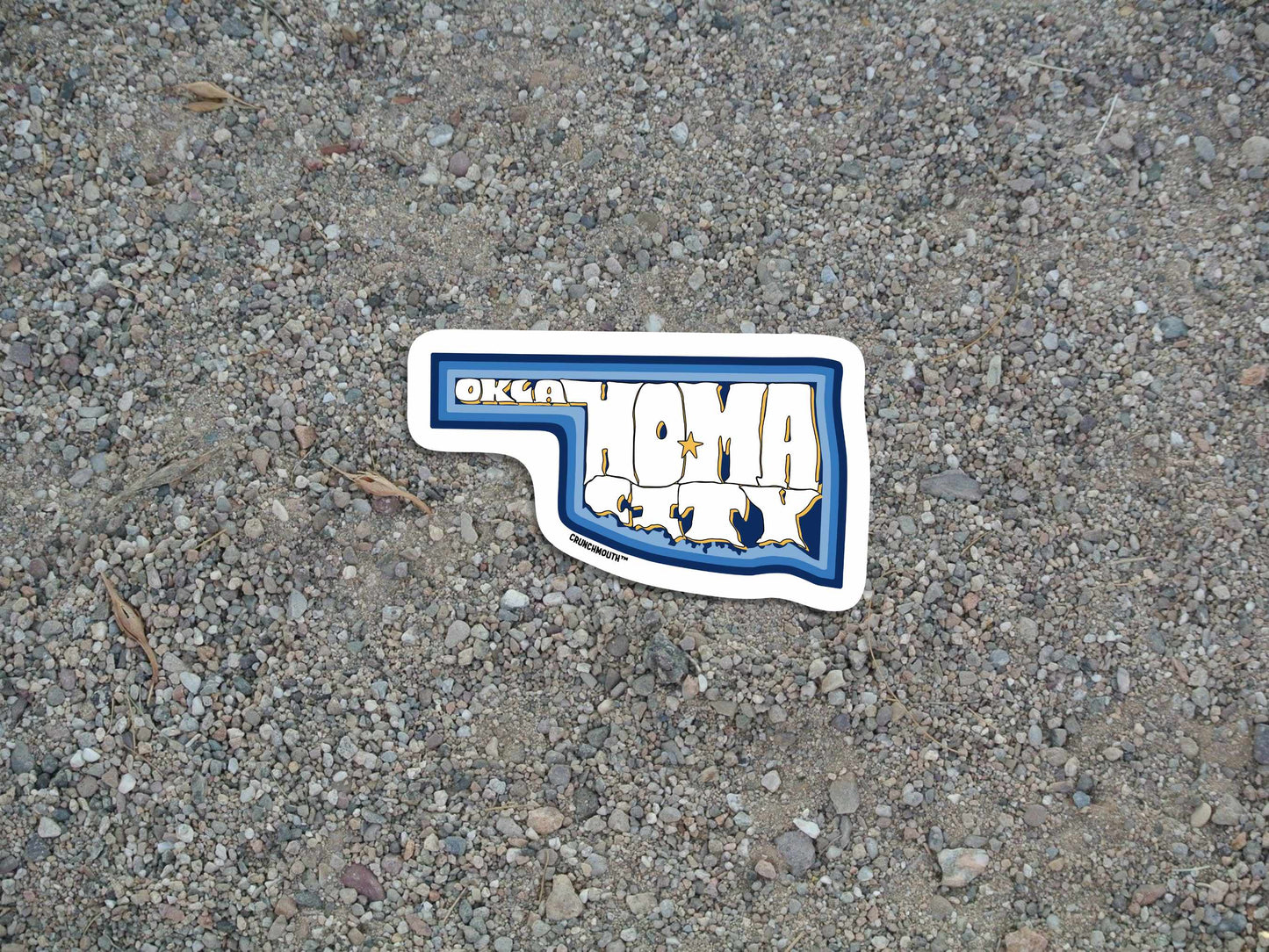 oklahoma city travel luggage sticker, hand display, gravel road background