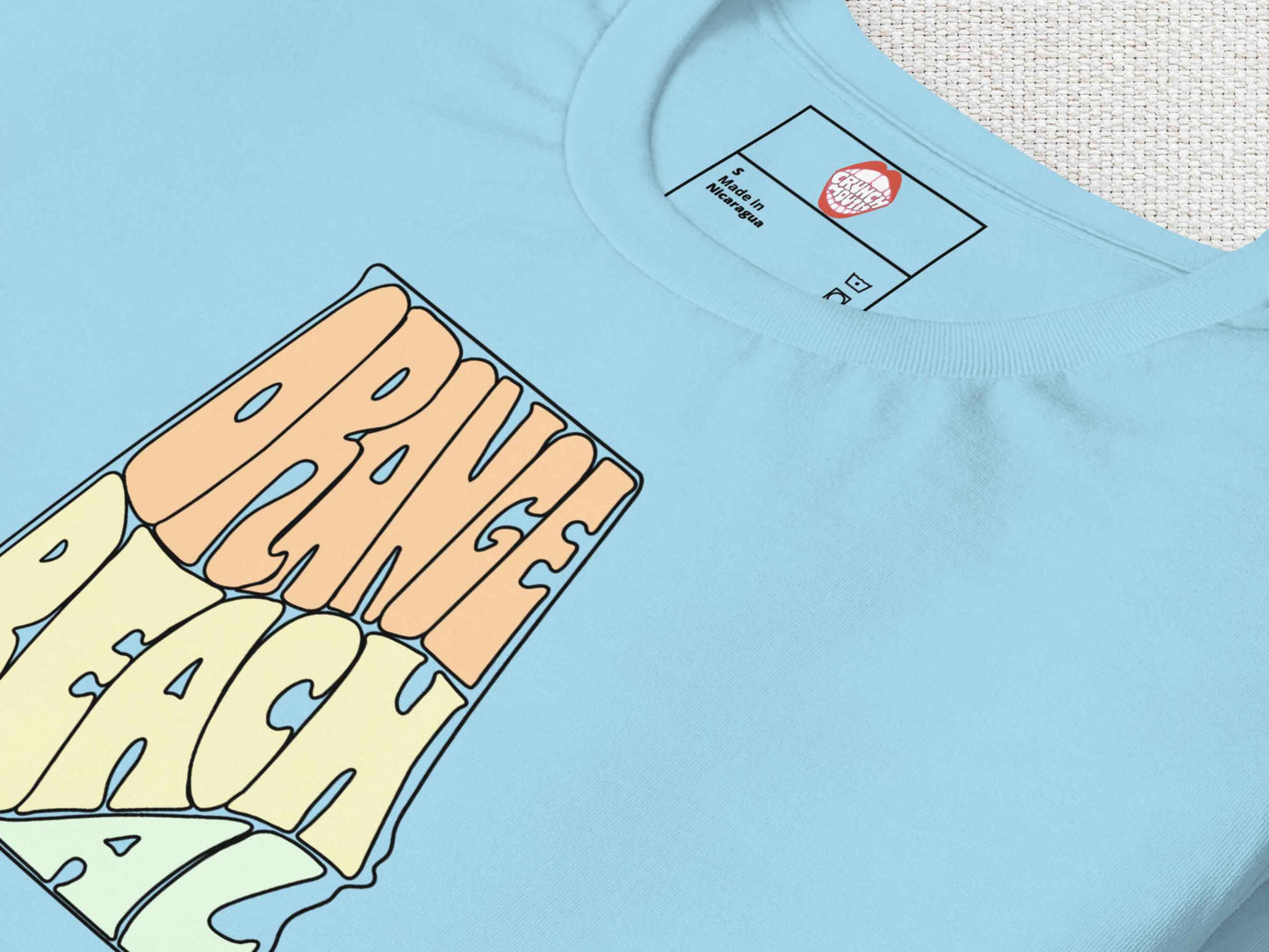 orange beach shirt, folded, front, close up, white textured background