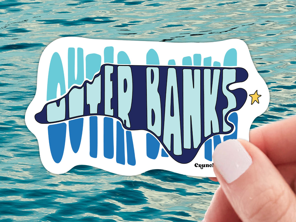 outer banks north carolina waterproof vinyl sticker, held in hand, water background