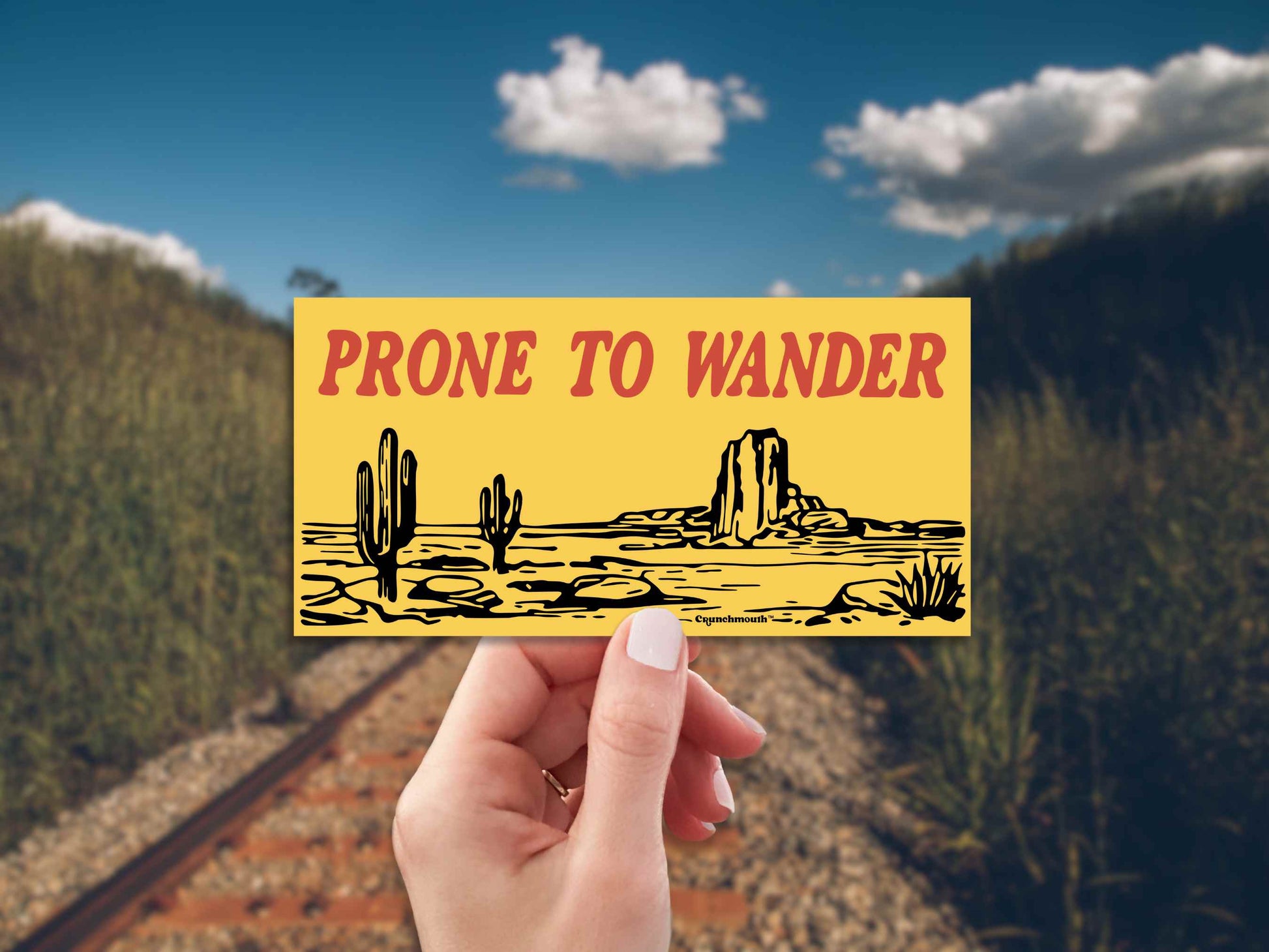 desert adventure bumper sticker, prone to wander, railroad tracks background