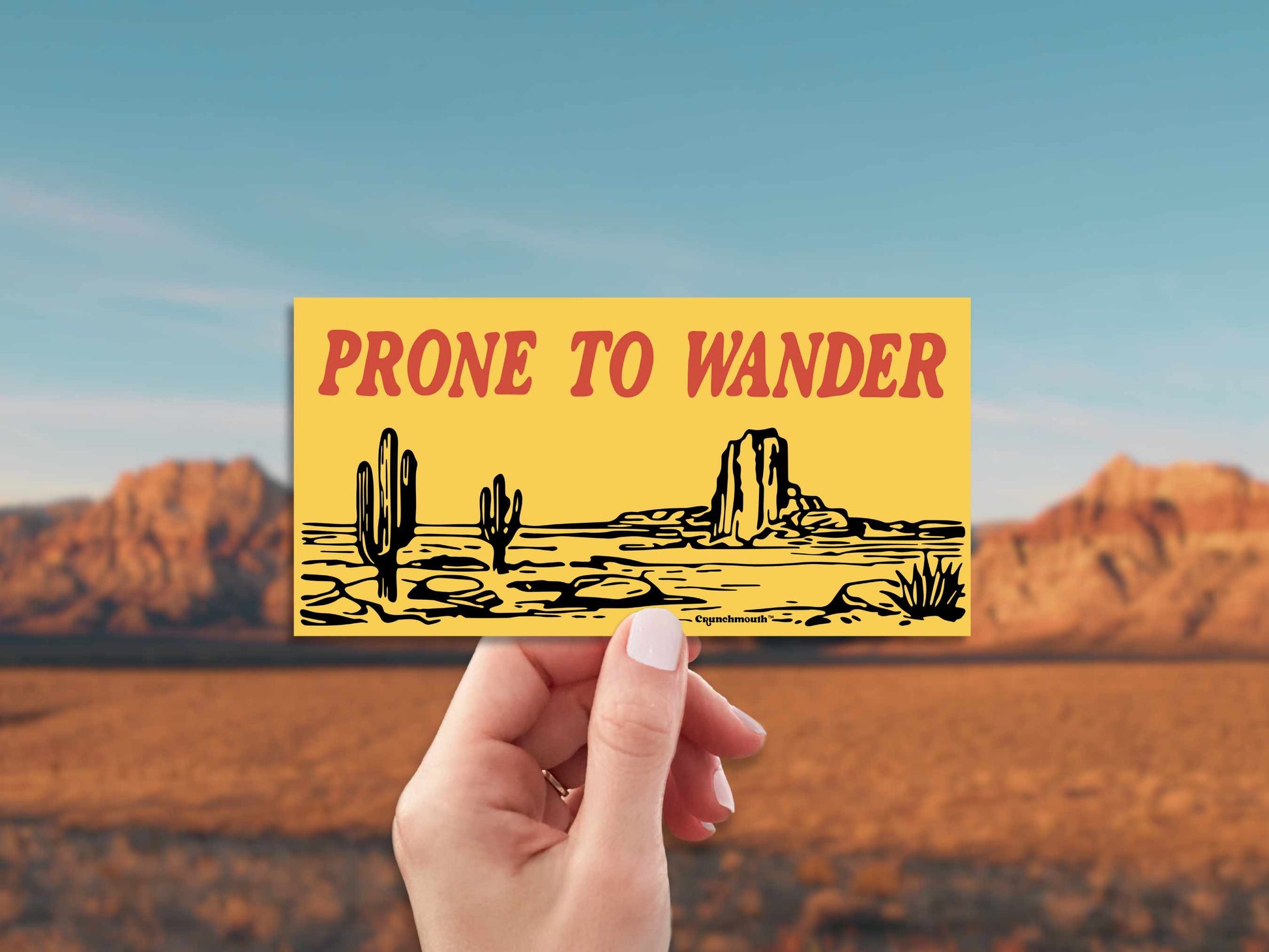 desert adventure bumper sticker, prone to wander, red rocks background
