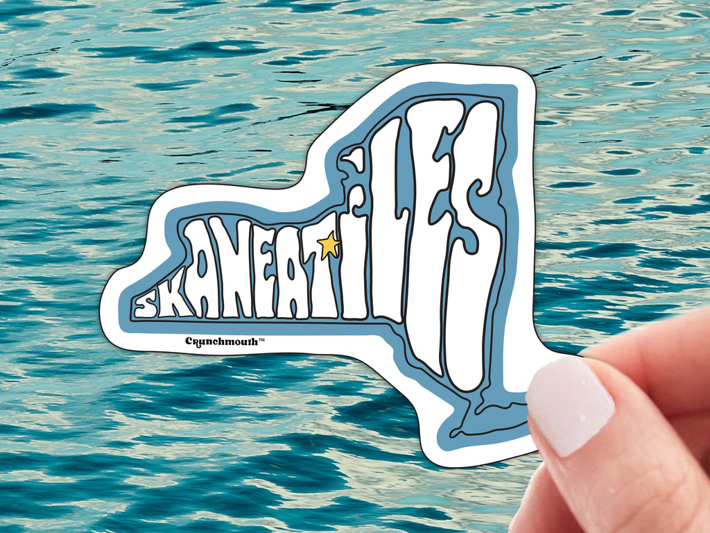 skaneateles waterproof vinyl laptop sticker, hand display, blue ocean water background
