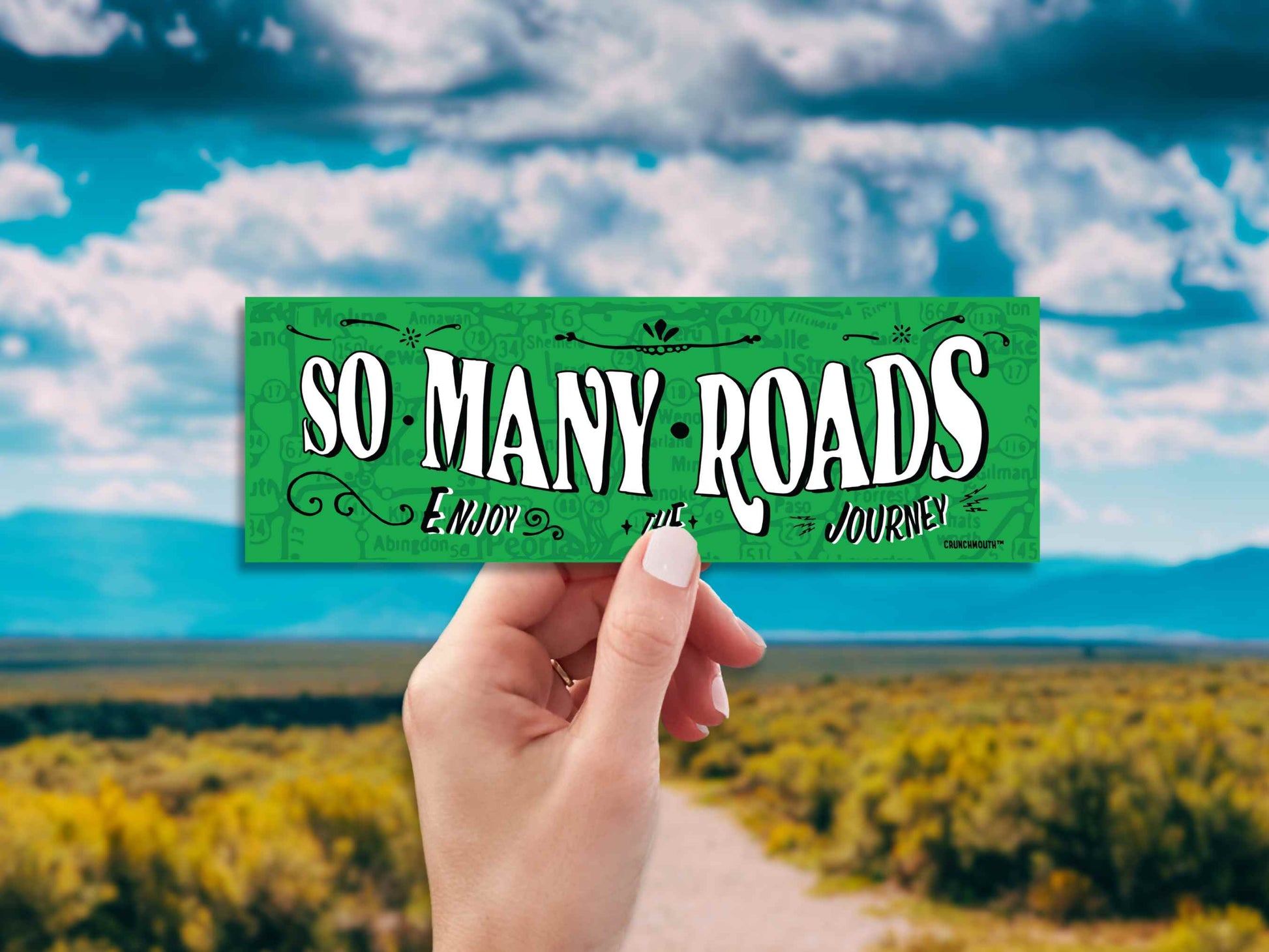 so many roads bumper sticker, hand display, dirt road landscape background