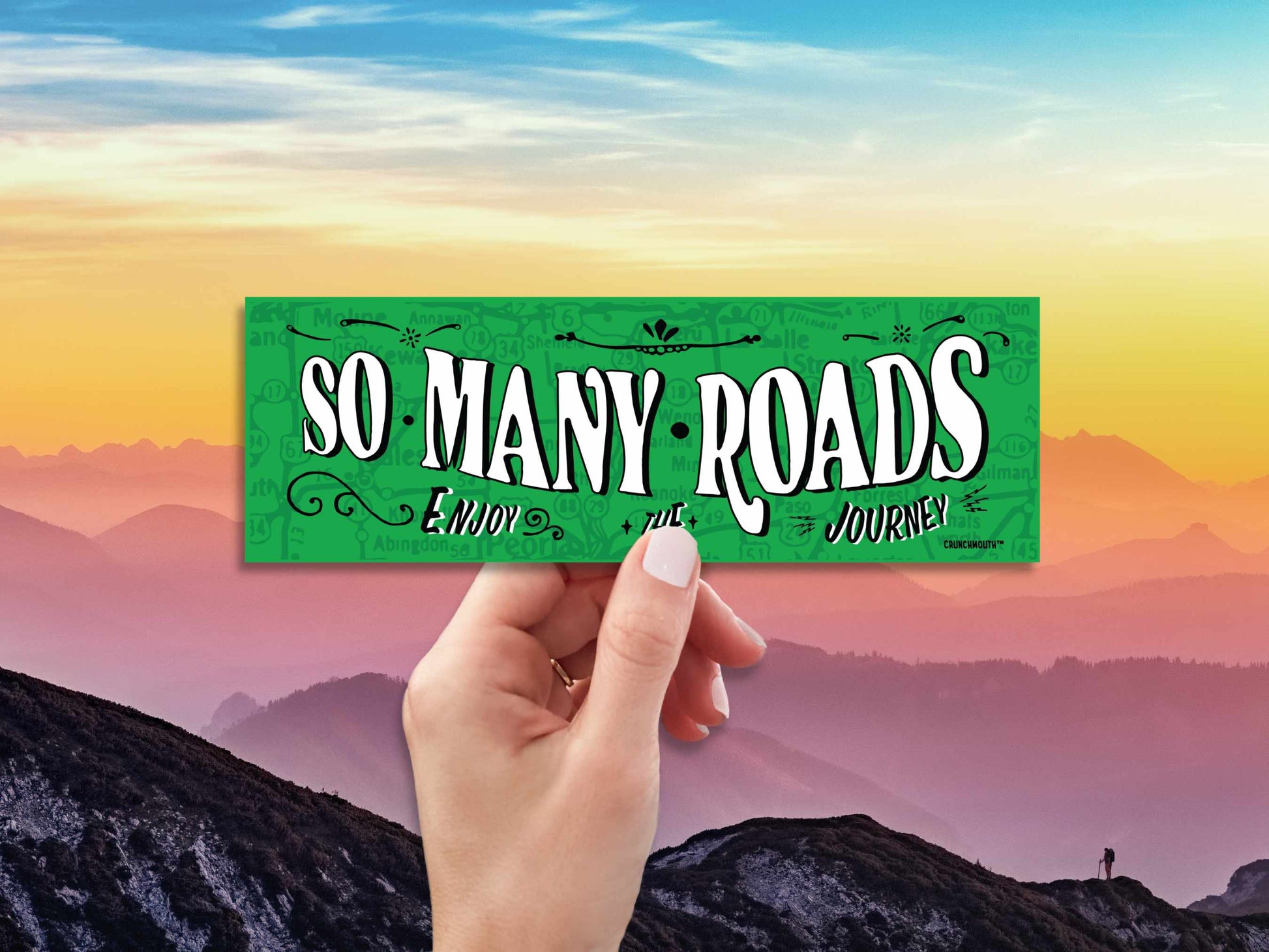 so many roads bumper sticker, hand display, mountain horizon background