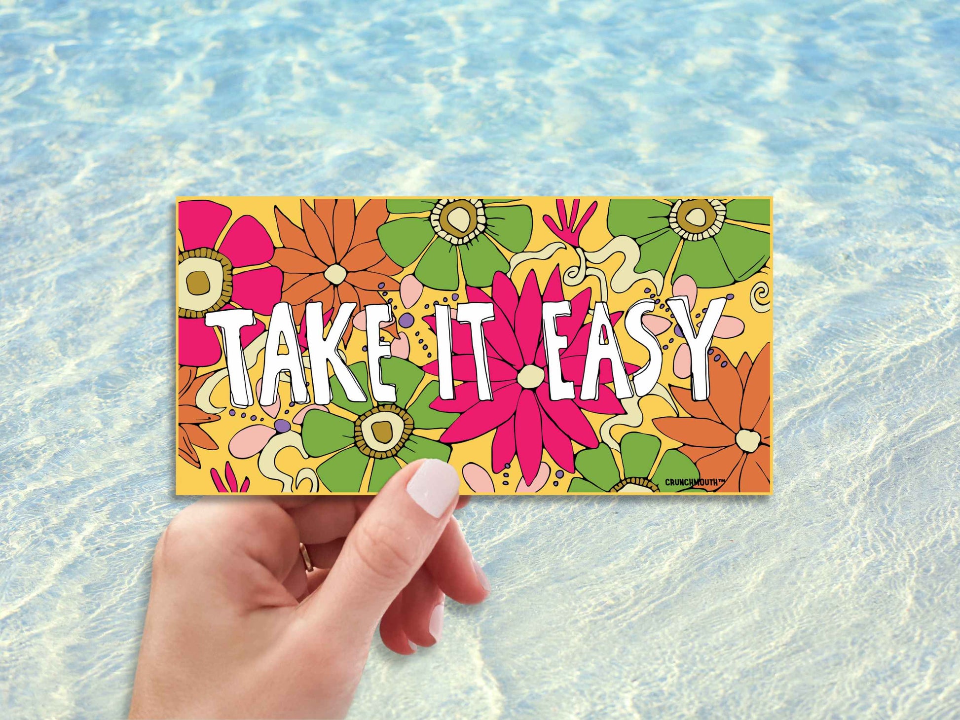 take it easy bumper sticker, hand display, beach ocean water background