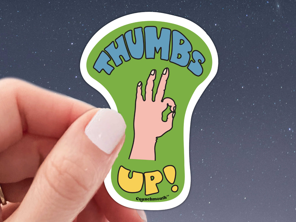 thumbs up sticker, held in hand, starry night background