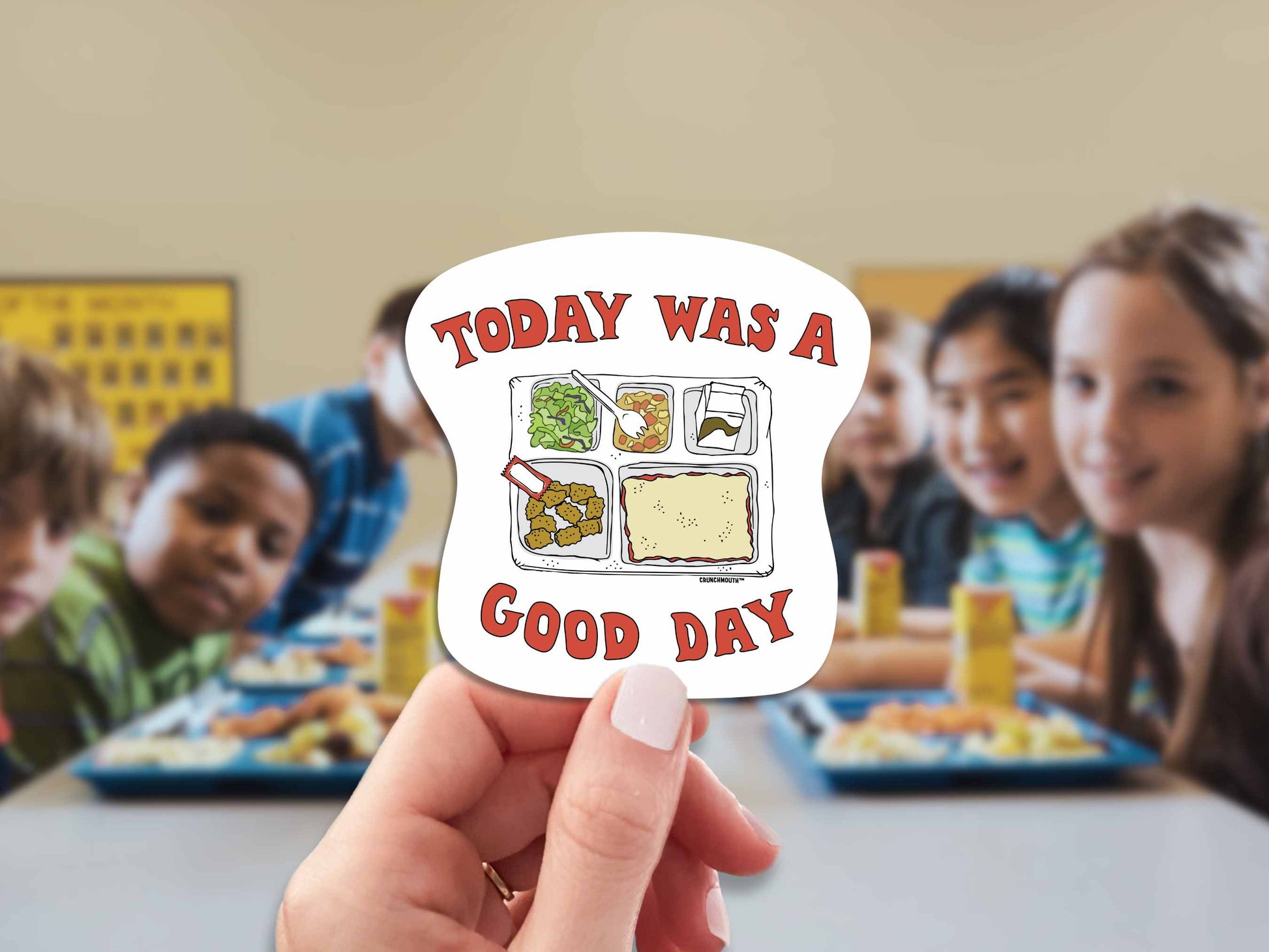 school lunch sticker, today was a good day, hand display, cafeteria table full of kids background