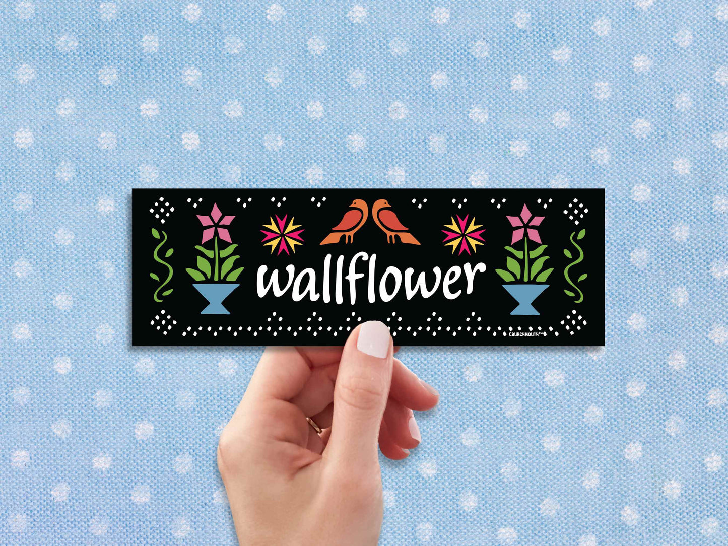 wallflower bumper sticker, hand display, blue polka dot fabric background