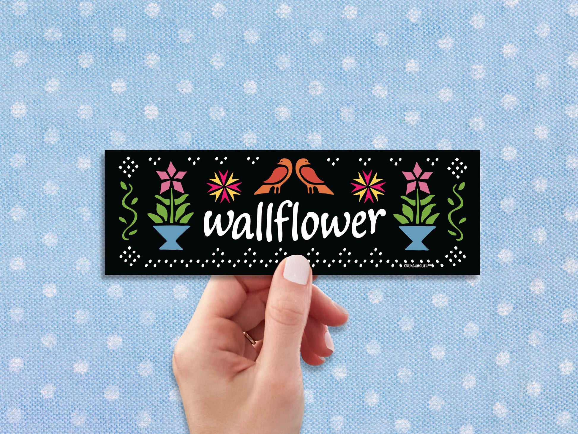 wallflower bumper sticker, hand display, blue polka dot fabric background