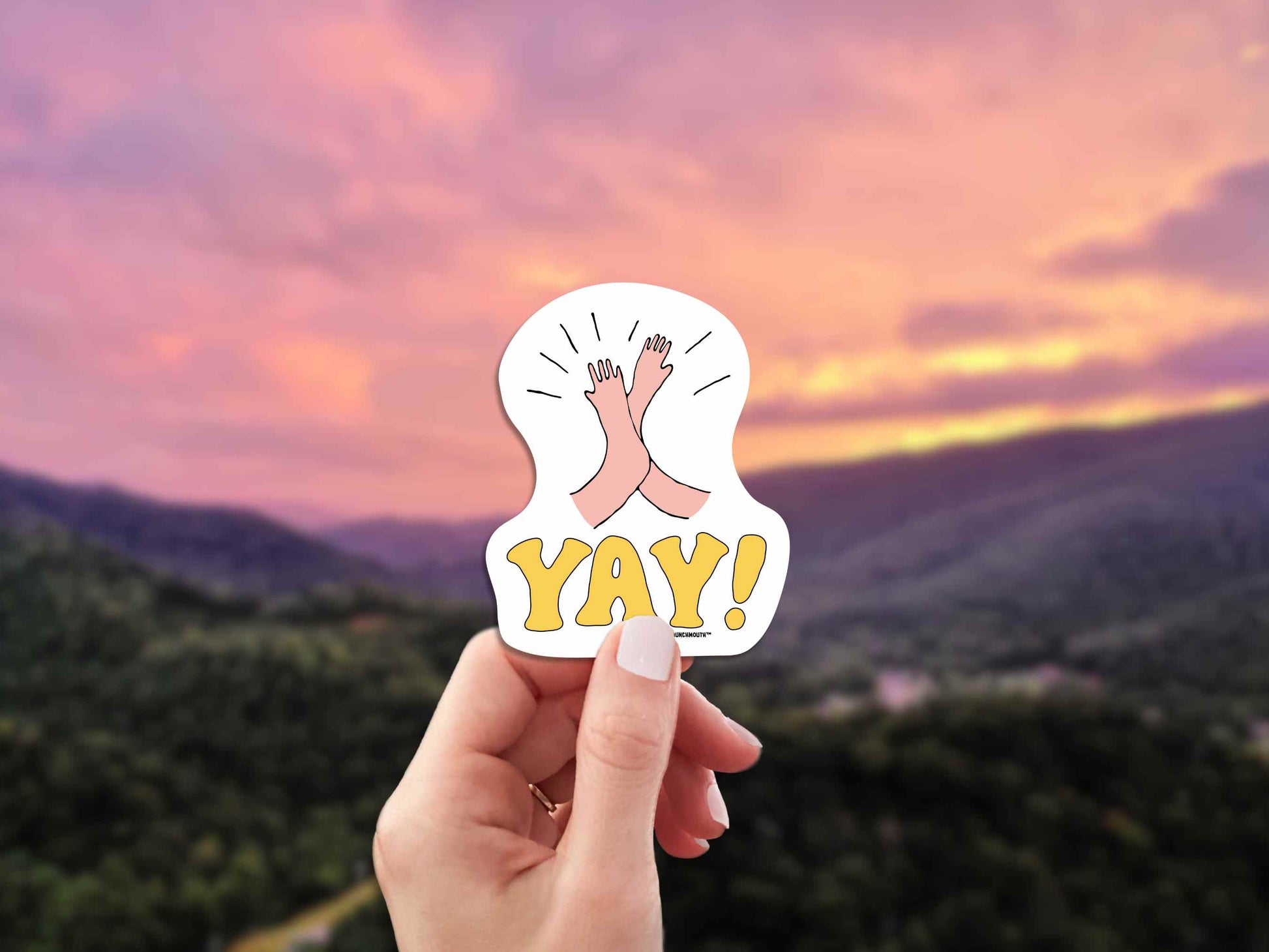 high five yay sticker, hand display, sunset over mountains background