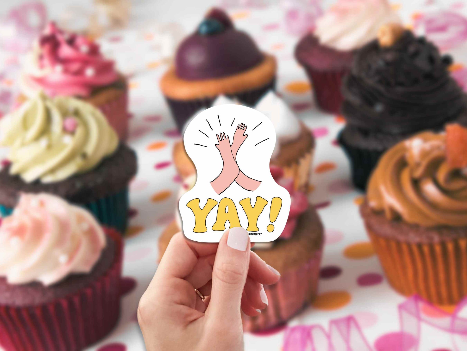 high five yay sticker, hand display, cupcakes background