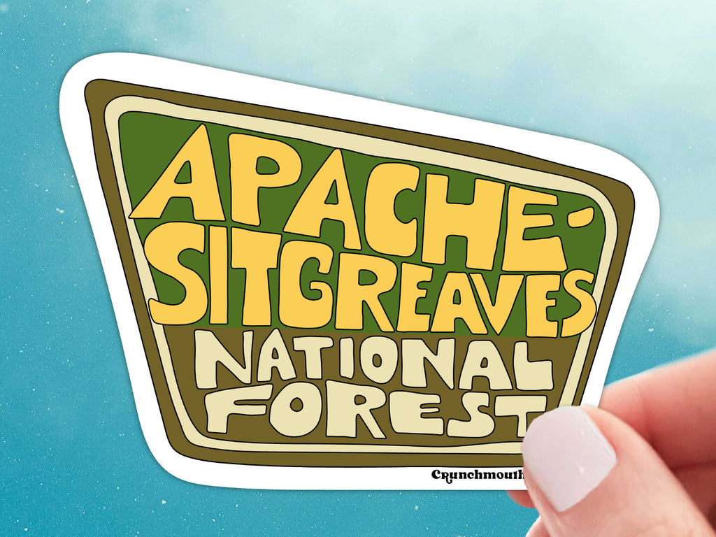 apache-sitgreaves national forest vinyl sticker, held in hand, blue sky background