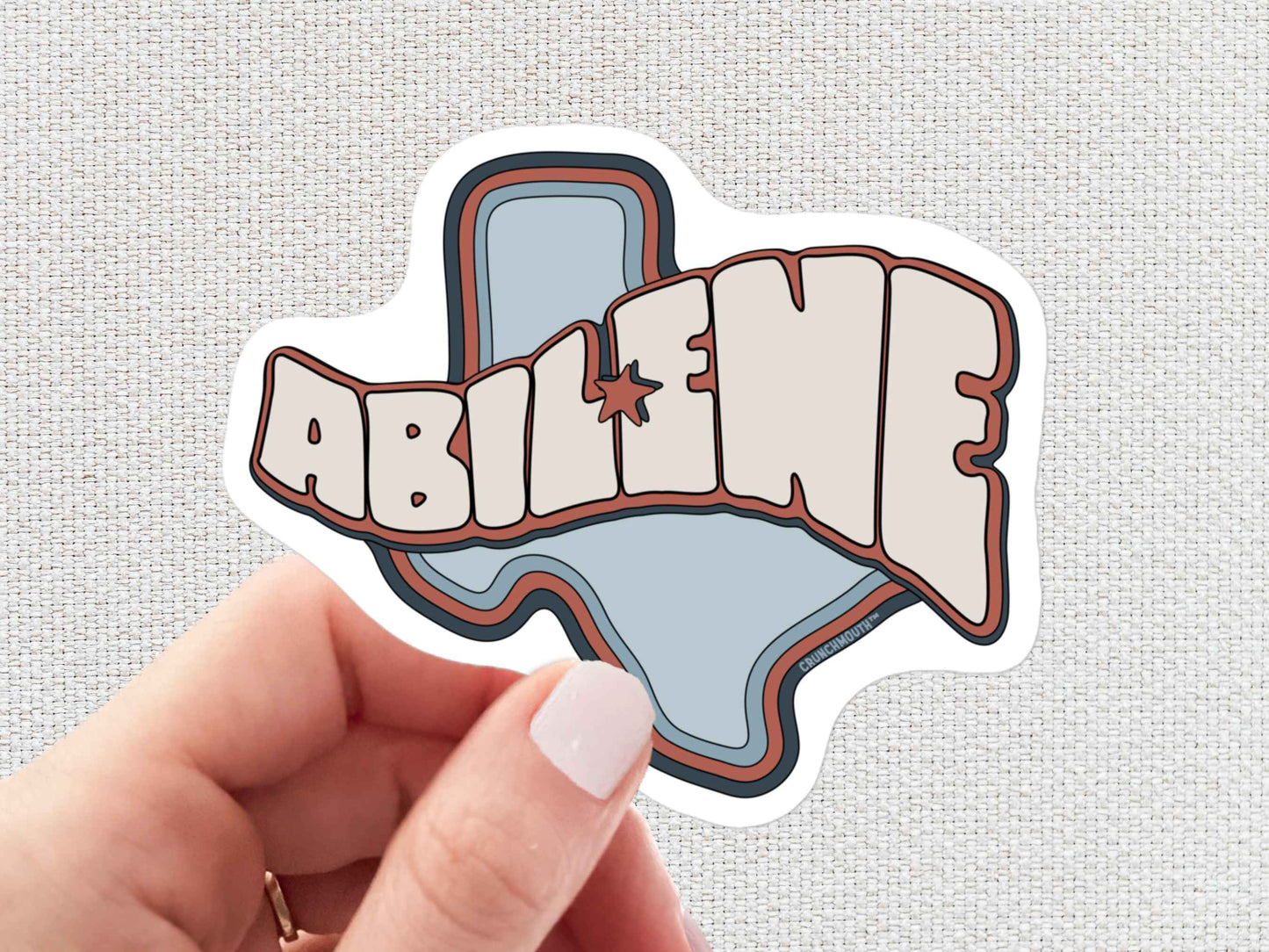 abilene sticker, hand display, white textured background