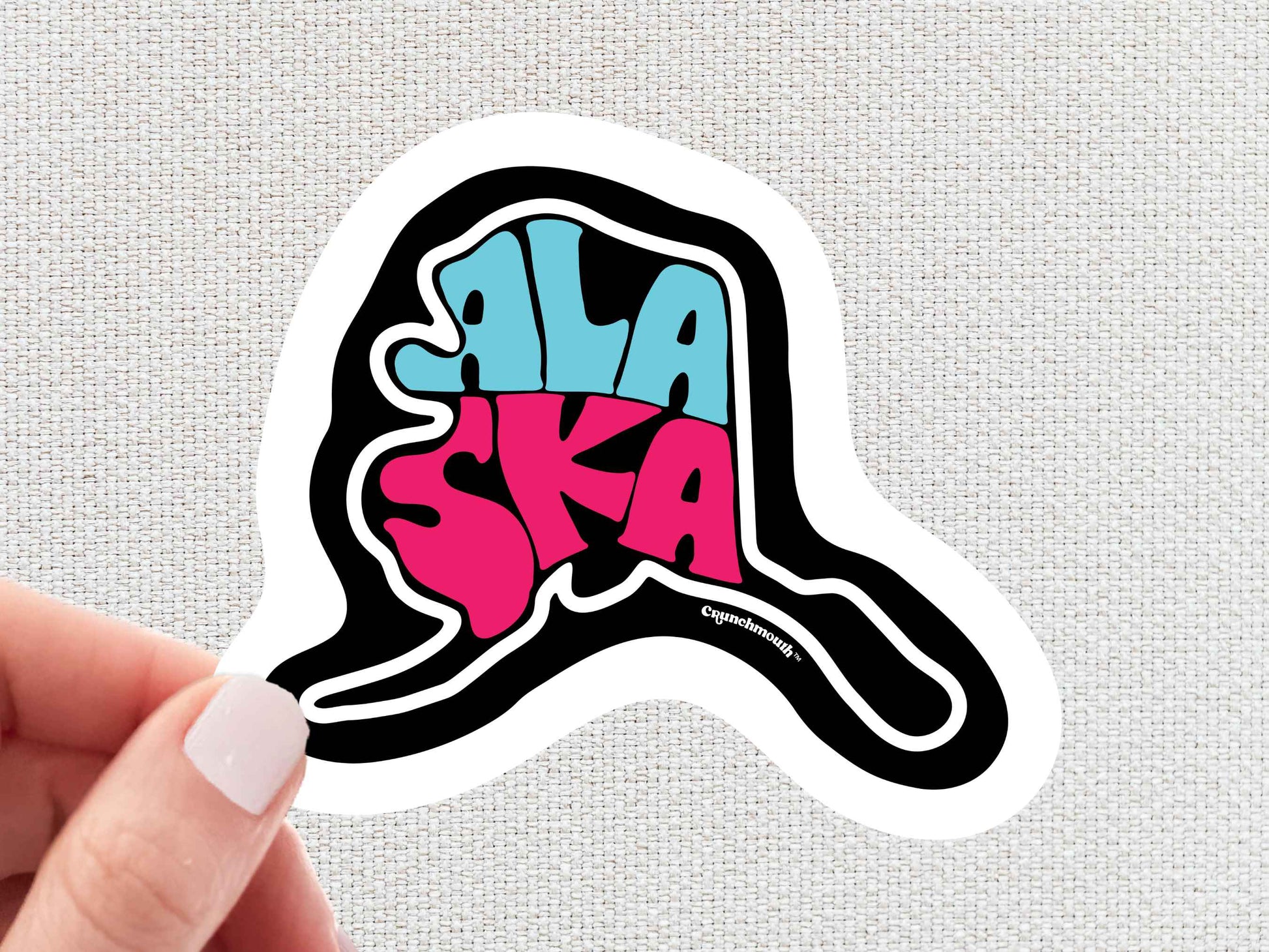 alaska travel luggage sticker, hand display, white textured background