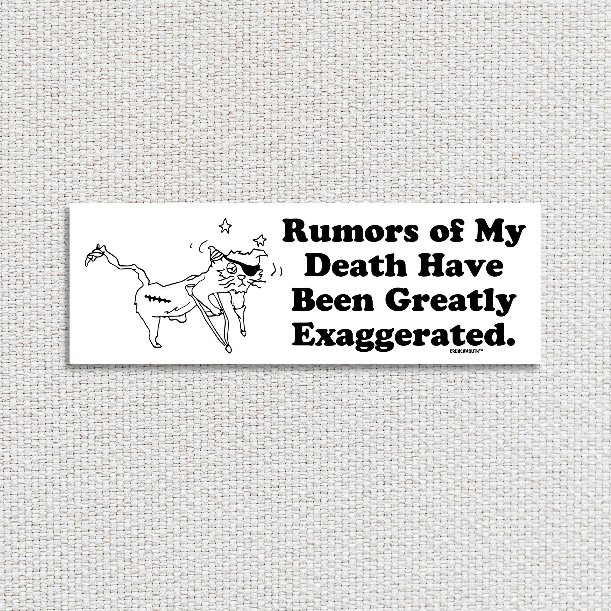 rumors of my death have been greatly exaggerated bumper sticker, textured fabric background
