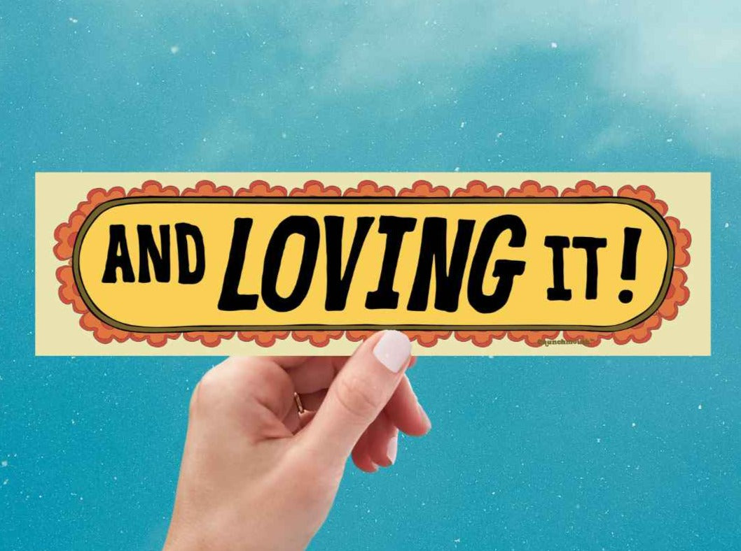 and loving it! bumper sticker, get smart quotes, hand display, blue sky background