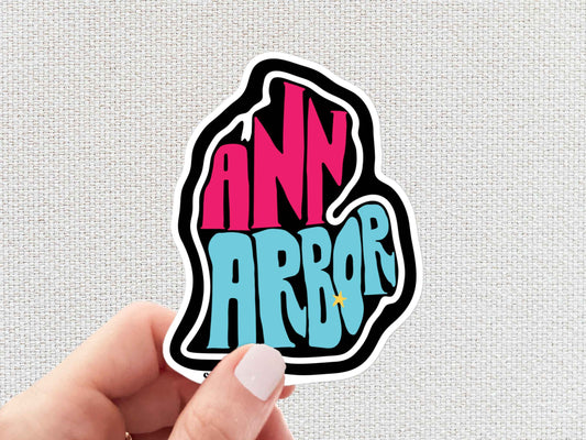 ann arbor sticker, hand display, white textured background