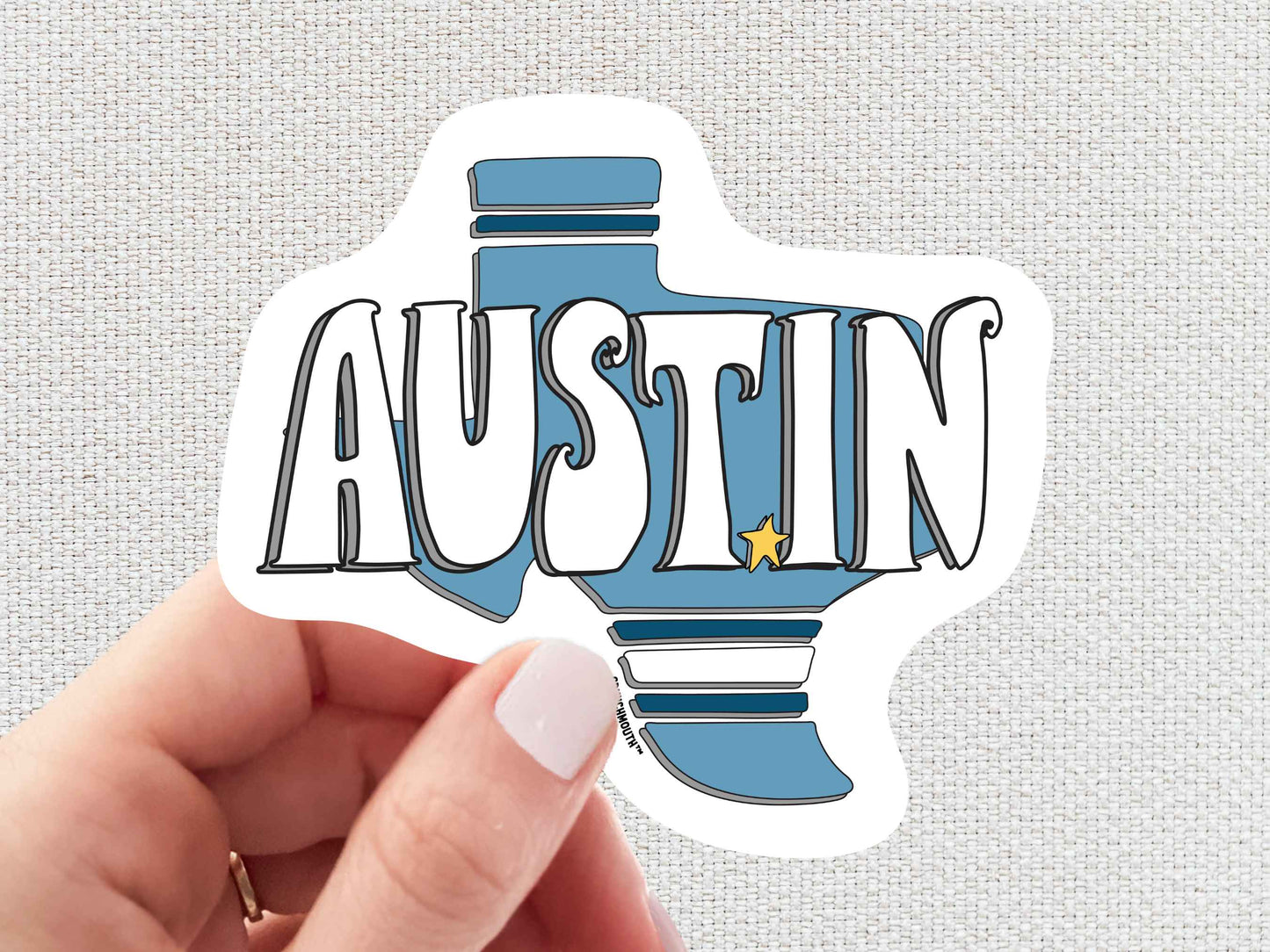 austin sticker, hand display, white textured background