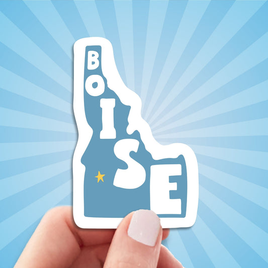 boise travel luggage sticker, hand display, sun rays design background
