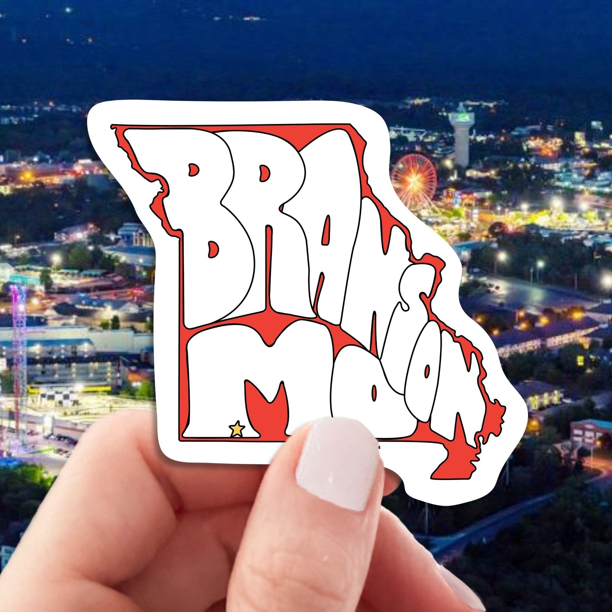 branson travel luggage sticker, hand display, branson city at night background
