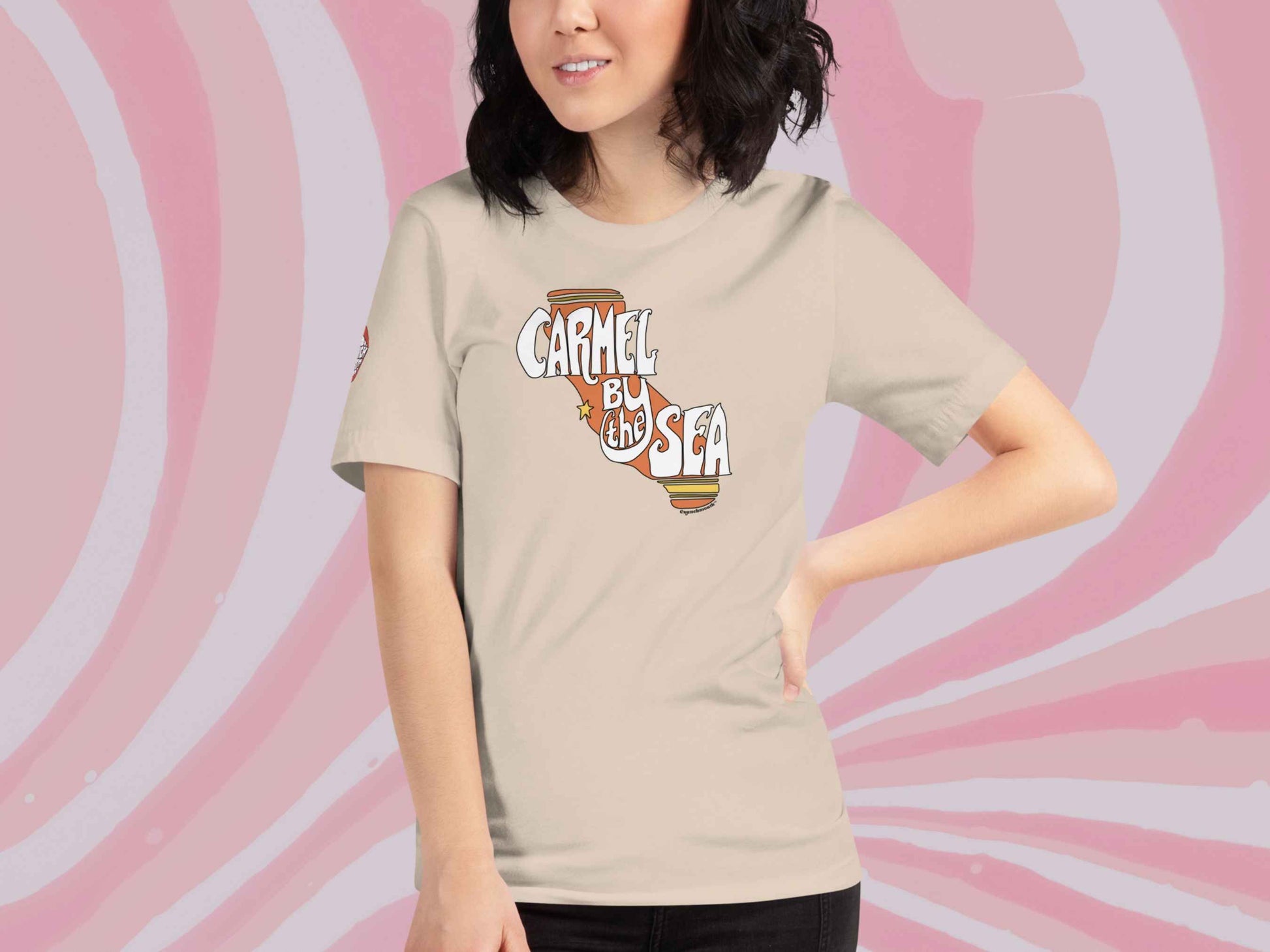 carmel by the sea shirt, souvenir t shirts, front, female model, pink swirls background