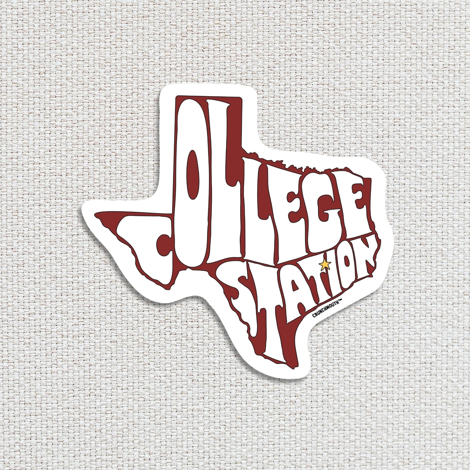 college station travel luggage sticker, hand display, white textured fabric background