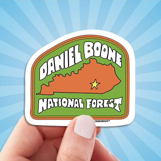 Daniel boone national forest travel luggage sticker, hand display, sun rays design background
