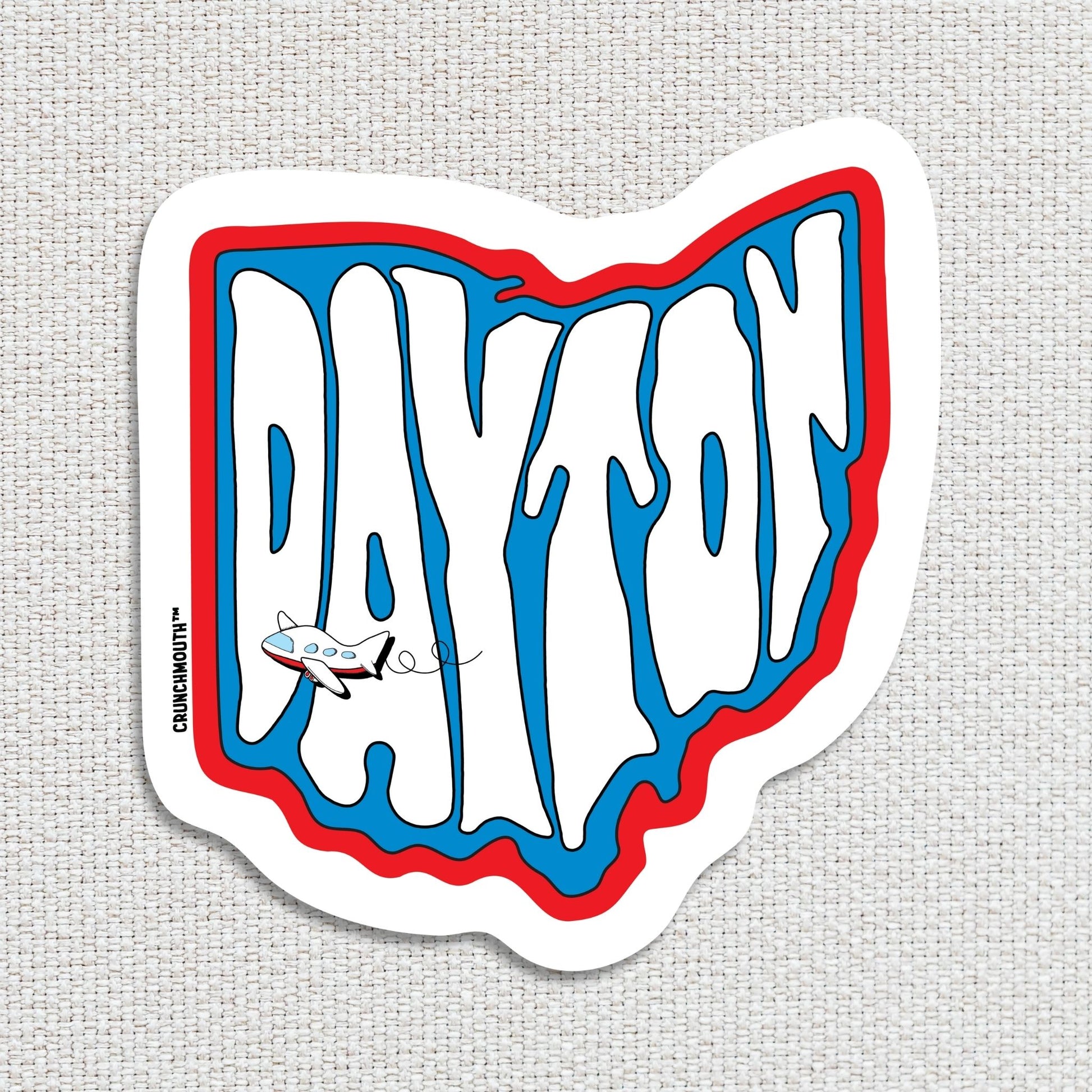dayton travel luggage sticker, hand display, textured fabric background