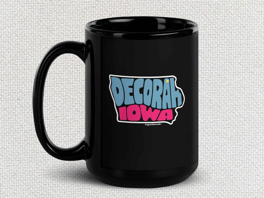 decorah mug, souvenir coffee mugs, 15oz, black ceramic, handle on left, light color textured background