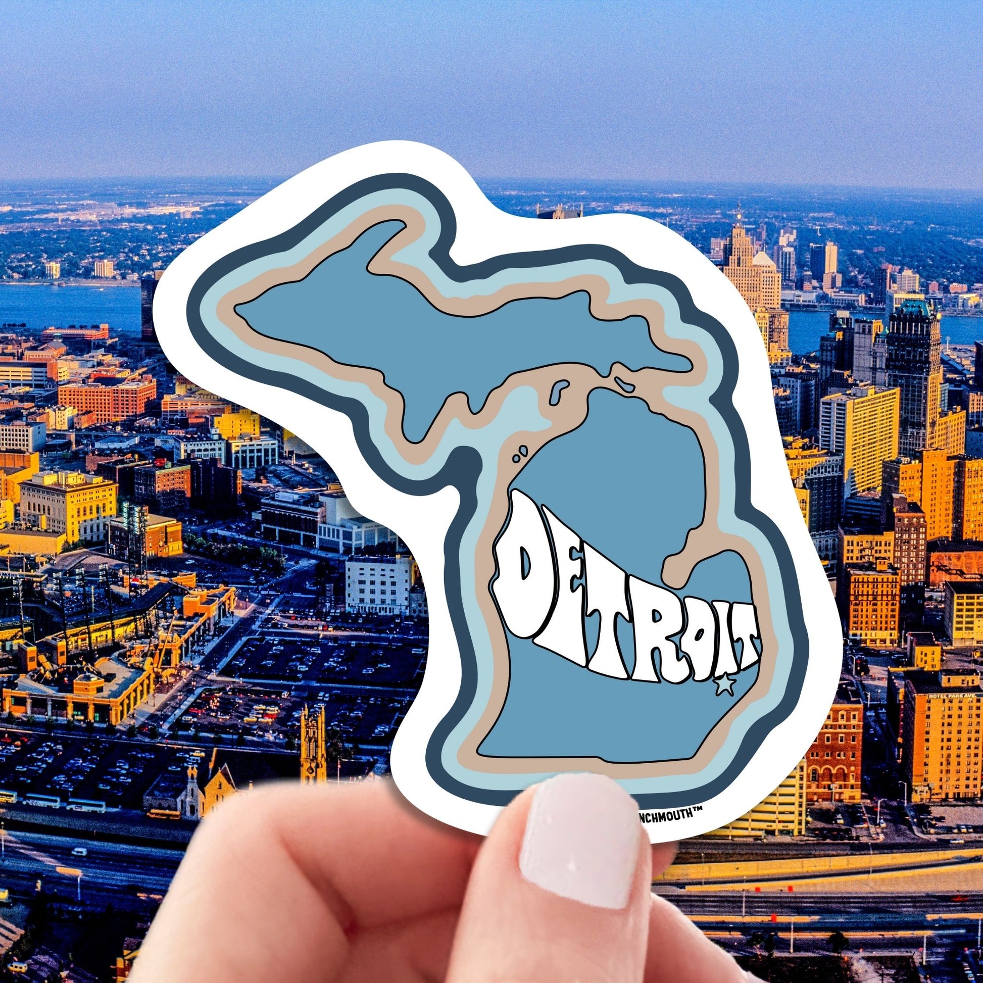 detroit travel luggage sticker, hand display, aerial cityscape background