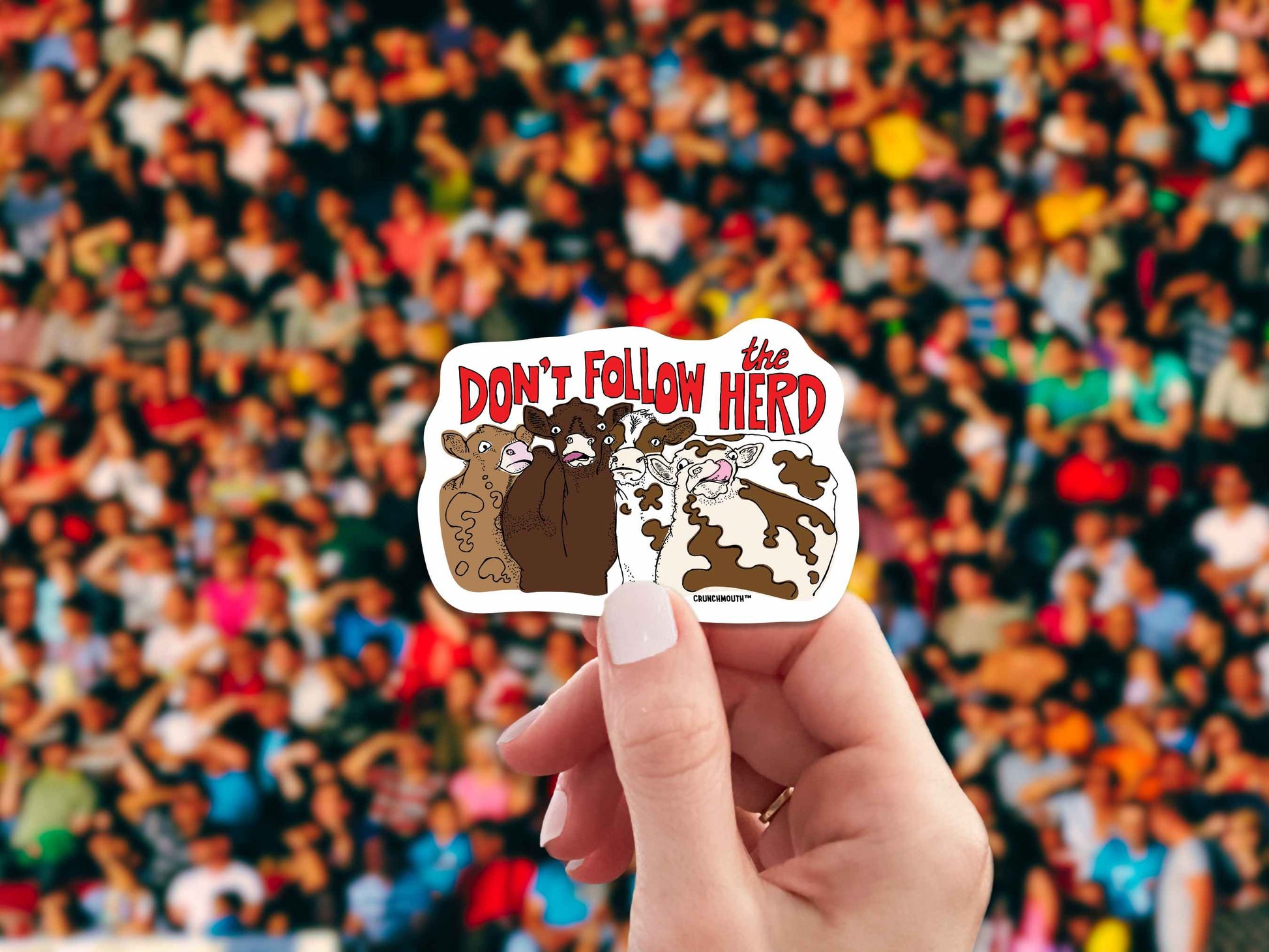 don't follow the herd sticker, hand display, crowd background