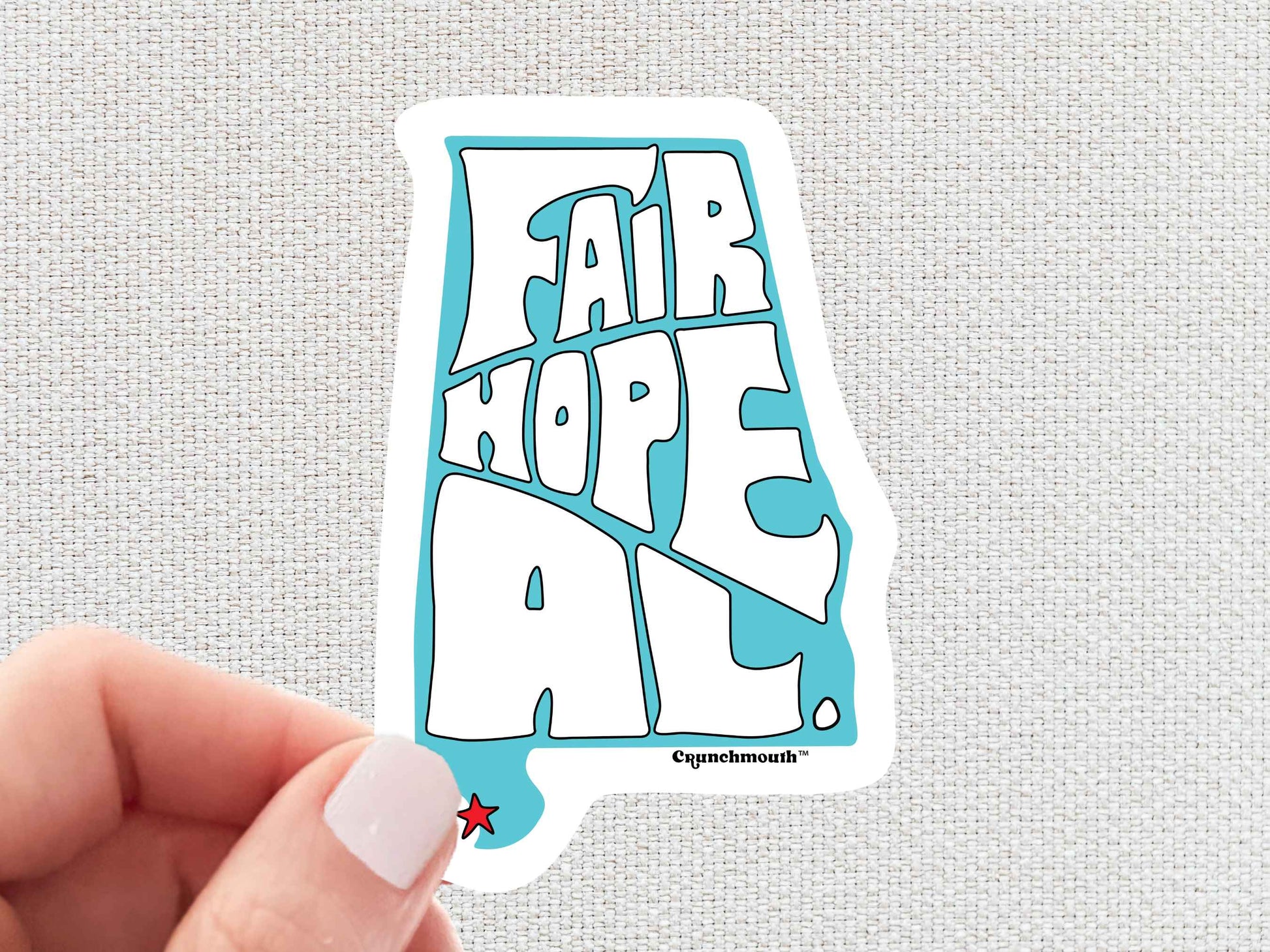 fairhope alabama sticker, hand display, white textured background